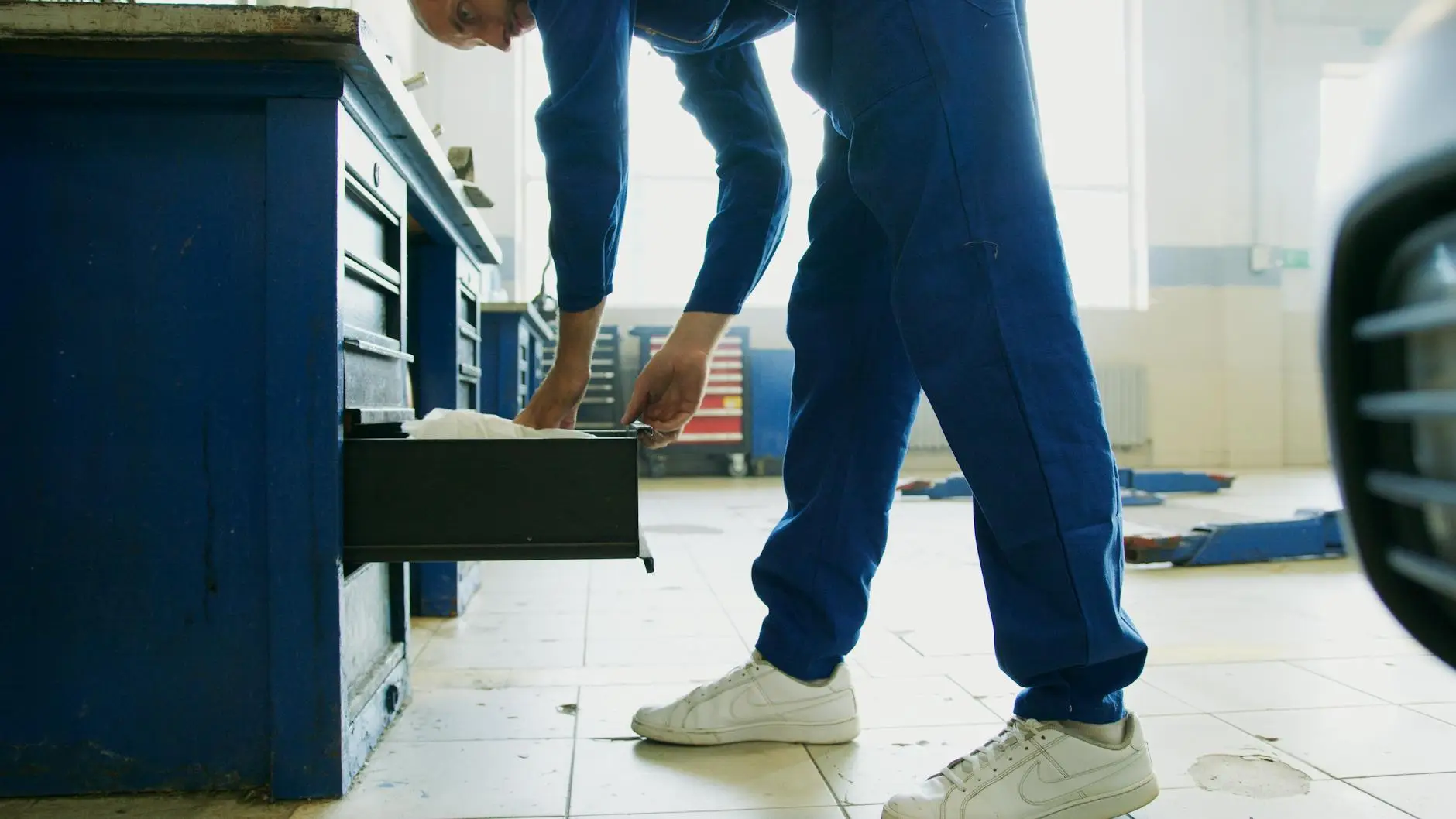 A certified technician using a professional moisture meter to check for hidden dampness behind a drywall wall.